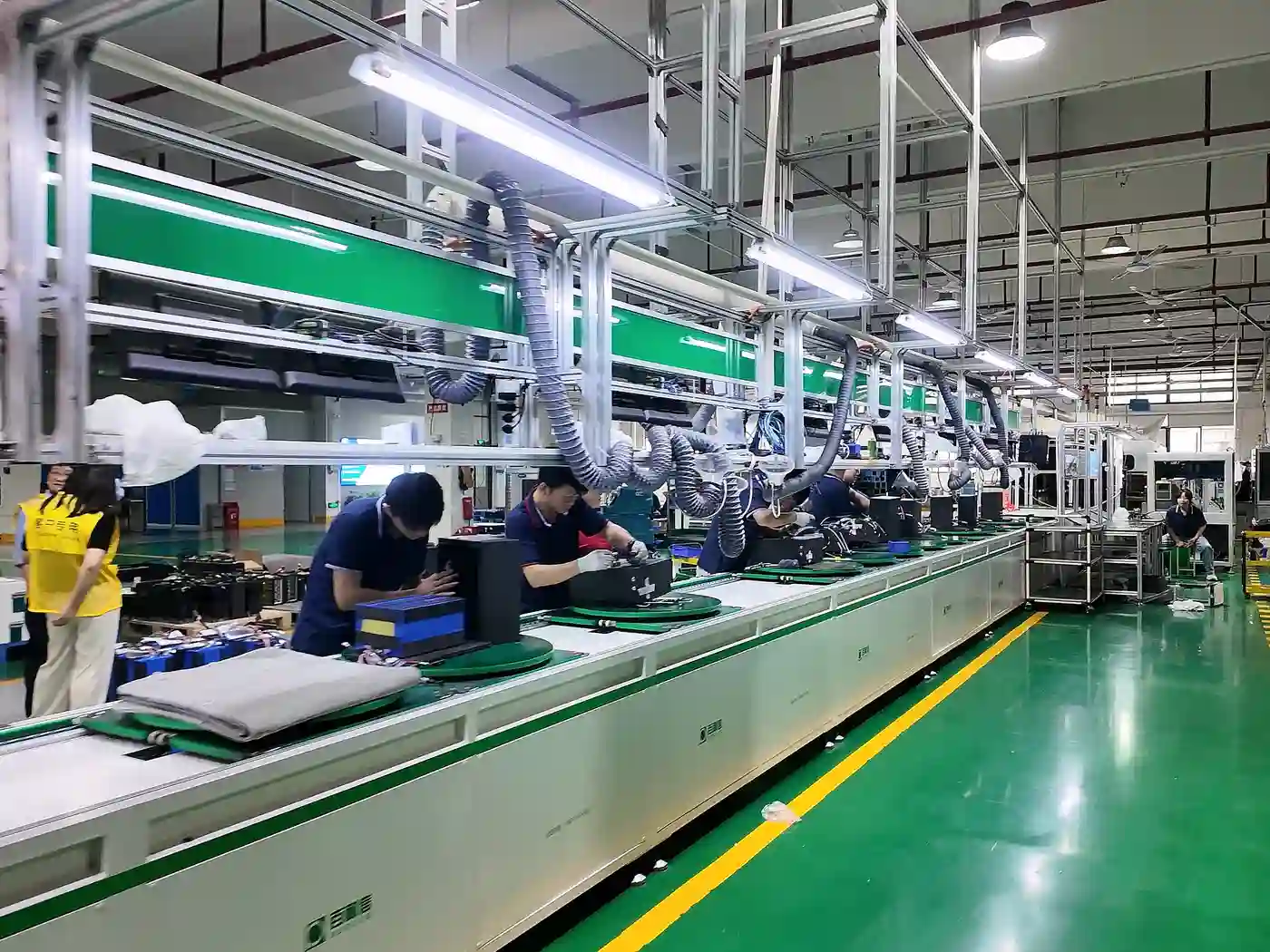 Battery pack assembly line with technicians working at production stations